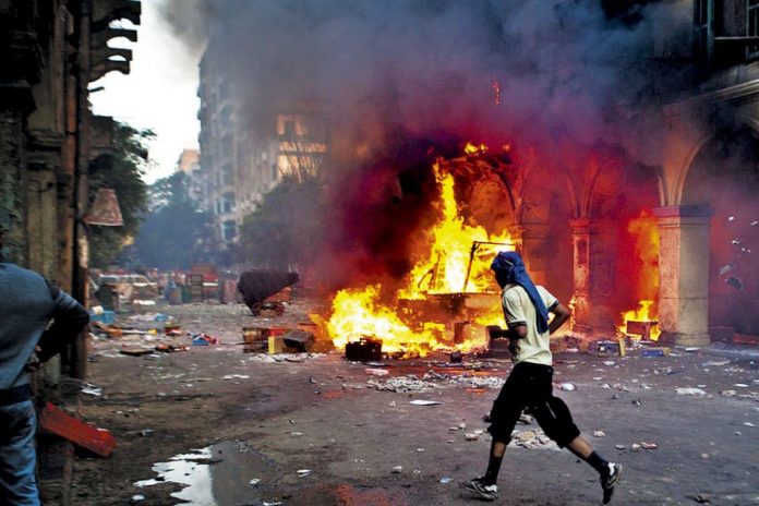 Un seguidor del presidente derrocado, Mohamed Mursi, pasa frente a un vehículo quemado en la plaza Ramses en El Cairo, uno de los epicentros de las protestas y la represión del ejército. Y la sangre llegó al Nilo.